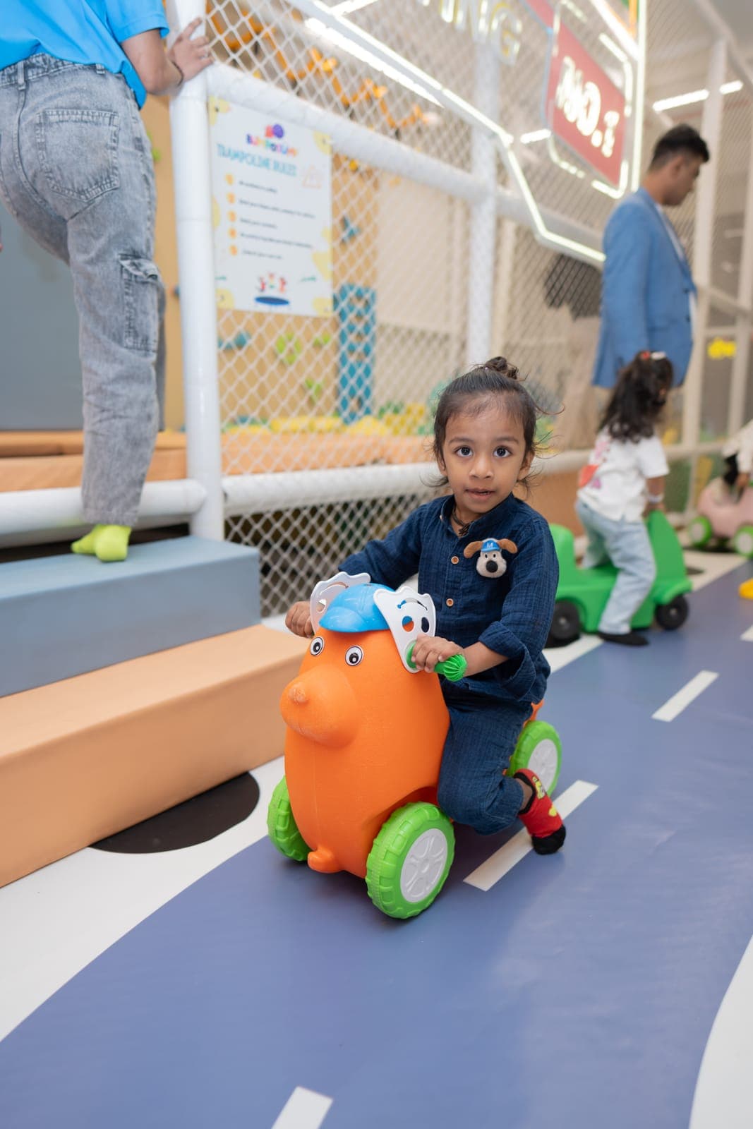 Toddler riding a ride-on toy along the play track